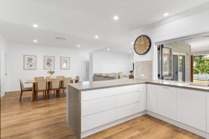 Modern contemporary home exterior with warm entry lighting and landscaped front garden.