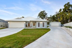 Contemporary home exterior with warm entrance lighting and landscaped driveway.
