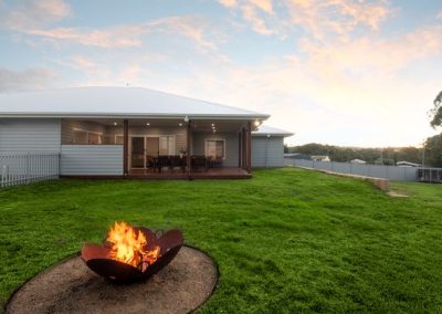 Flynn Dr, 54 (33) | Freeman Quality Builder Warwick QLD Contemporary exterior of a brick and timber home with illuminated porch at dusk.