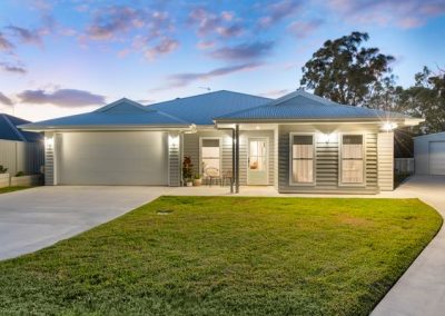 Flynn Dr, 54 (38) | Freeman Quality Builder Warwick QLD Modern single-story home facade with lit entry and attached garage at dusk.