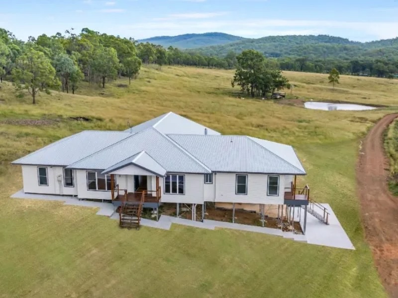 freeman copy | Freeman Quality Builder Warwick QLD A house situated in an open field, connected by a dirt road that stretches towards it.
